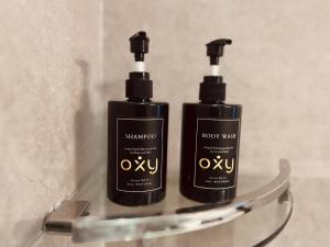 two bottles of shampoo are sitting on a shelf at oxy suites 2-06 at Shop House Meisterstadt Pollux Habibie in Batam Center