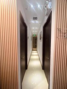 a hallway with two doors and a long corridor at oxy suites 2-06 at Shop House Meisterstadt Pollux Habibie in Batam Center