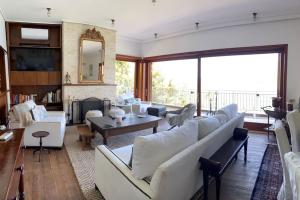 a living room with white couches and a fireplace at Bellavista at Heraion Lagoon in Loutraki