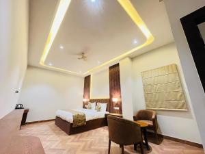 une chambre d'hôtel avec un lit, une table et des chaises dans l'établissement HOTEL EKAS, à Charbagh