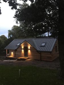 a small wooden house with lights on it at The Hen House A beautifully situated open plan chalet in Lothersdale