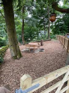 a park with a bench next to a tree at The Hen House A beautifully situated open plan chalet in Lothersdale