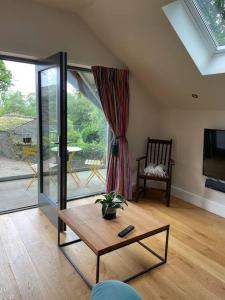 a living room with a coffee table and a tv at The Hen House A beautifully situated open plan chalet in Lothersdale