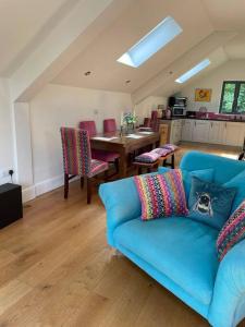 a living room with a blue couch and a table at The Hen House A beautifully situated open plan chalet in Lothersdale