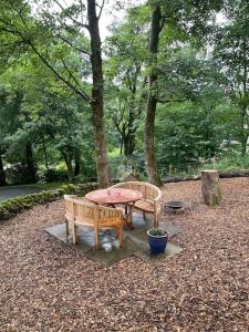two benches and a table in a park at The Hen House A beautifully situated open plan chalet in Lothersdale