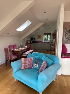 a blue couch with pillows on it in a living room at The Hen House A beautifully situated open plan chalet in Lothersdale