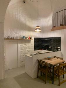 eine Küche mit einem Tisch und einer Arbeitsplatte in der Unterkunft La Piccola Tufaia in Fasano