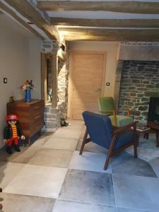 a living room with a stone fireplace and a blue chair at Le Terrier in Miserey-Salines