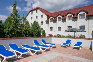 a group of blue and white chairs next to a pool at Hotel Horda in Słubice