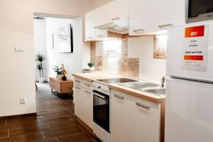 a kitchen with white cabinets and a sink at Internesto Brno Luzanky in Brno
