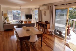 a living room with a table and chairs and a couch at Blue Skies Beach House in Gerringong
