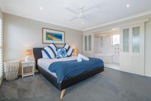 Un dormitorio con una cama tamaño king y un baño. en EastsHaven, en Kiama