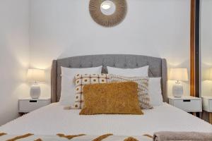 a bedroom with a white bed with two lamps at Minnamurra Retreat 2 in Minnamurra