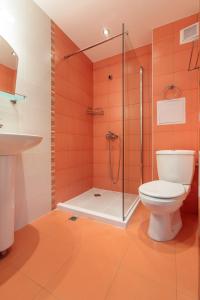 a bathroom with a toilet and a glass shower at Via Pontica 123 Guest Apartments in Sozopol