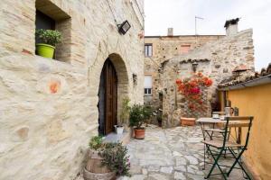 een stenen gebouw met een tafel en stoelen op een binnenplaats bij Casa castello in Rocca Imperiale