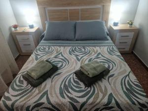 ein Schlafzimmer mit einem Bett mit zwei Kissen darauf in der Unterkunft Deea Beach in Cullera