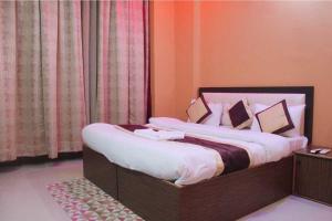 a bedroom with a bed with white sheets and pillows at The Hotel Raj Palace in Bharatpur