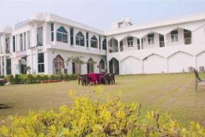 a large building with a table and horses in a yard at The Hotel Raj Palace in Bharatpur