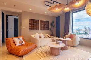 sala de estar con muebles de color naranja y ventana grande en Tropicana 218 Macalister X Airlevate Suites, en George Town
