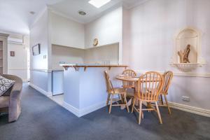 a kitchen and dining room with a table and chairs at Foreshore Apartment 104 in Albany +18 photos