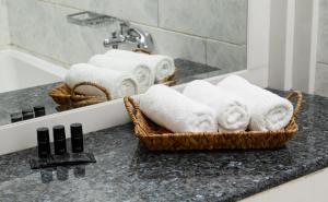 a basket of towels on a counter in a bathroom at El Greco Hotel in Agios Nikolaos