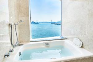 a bath tub with a large window in a bathroom at InterContinental Tokyo Bay, an IHG Hotel in Tokyo