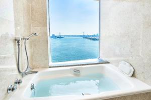 y baño con bañera y ventana grande. en InterContinental Tokyo Bay, an IHG Hotel en Tokio