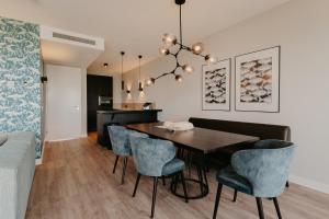 a dining room with a table and blue chairs at Residence Oude Haven in Colijnsplaat