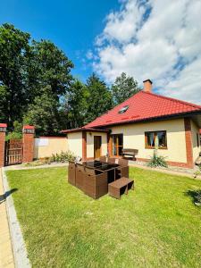 a house with a red roof with boxes in the yard at Niebieska Chmurka in Miłomłyn