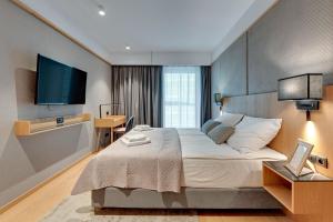 a hotel room with a bed and a flat screen tv at Flatbook - City Center Apartments Granaria I in Gdańsk