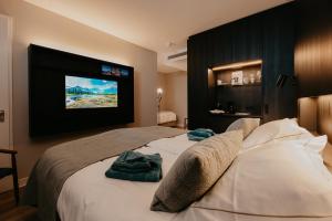 a hotel room with a bed with a television on the wall at Residence Oude Haven in Colijnsplaat