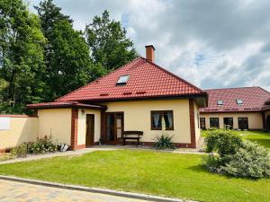 a small house with a red roof at Pod skrzydłami in Miłomłyn