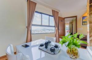 a dining room with a white table and a plant at Yen Vang Hotel & Apartment Nha Trang in Nha Trang