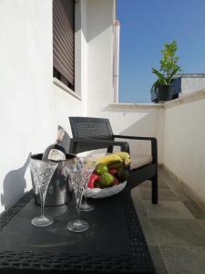 烏賈諾拉基耶薩的住宿－Casa Cinzia diamond 104，一张桌子,上面放着一碗水果和酒杯