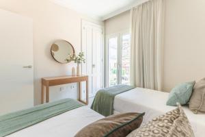 a hotel room with two beds and a mirror at Lavaderos Suites in Santa Cruz de Tenerife