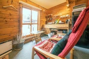 sala de estar con sofá y ventana en Alpages madarao, en Madarao Kogen