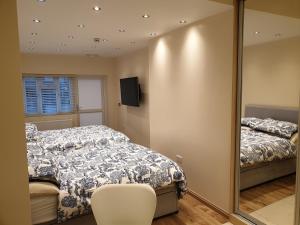 a bedroom with a bed and a mirror at London Luxury Apartments 3 Bedroom Sleeps 8 with 3 Bathrooms 4 mins walk to tube free parking in Ilford