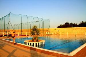 a man riding a skateboard next to a pool of water at Hotel Boutique Il Castellino Relais in Vieste
