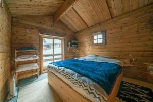 a bedroom with a bed in a wooden cabin at Alpages madarao in Madarao Kogen