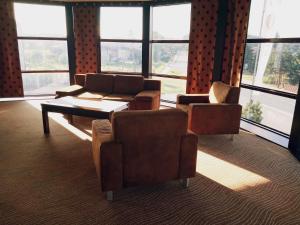 a living room with couches and a table and windows at Hotel Azalia & Spa in Niepołomice