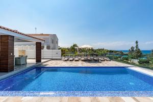 uma piscina numa villa com vista para o oceano em Beach Front Aqua Marina by Ezoria Villas em Paralimni