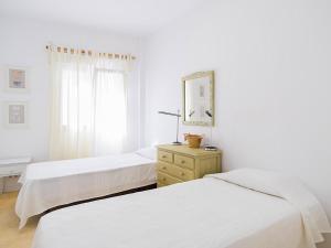 two beds in a bedroom with a mirror and a dresser at REf 38 CASA GUSTAVO in Zahara de los Atunes