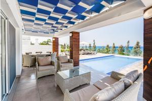 uma sala de estar com um sofá e uma piscina em Beach Front Aqua Marina by Ezoria Villas em Paralimni