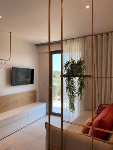uma sala de estar com uma grande janela e uma televisão em OliVISTA - Live in Nature em Astris