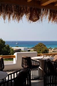 - une table avec des chaises et une vue sur l'océan dans l'établissement Mileo, à Kalo Livadi