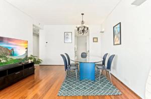 a dining room with a blue table and chairs at Beautiful 2-Bed Apartment with ocean views of Barangaroo in Sydney
