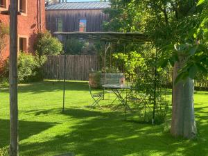 a garden with a table and a swing at Casale Caldesòra AgriBoutique BnB the Charme in Vittorio Veneto