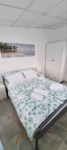 a bedroom with a bed with a green and white blanket at Apartment M&M Izola in Izola