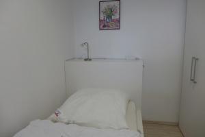 um quarto branco com uma cama com uma fotografia na parede em Tief 12 Seepferdchen mit Internet 24 em Wangerland