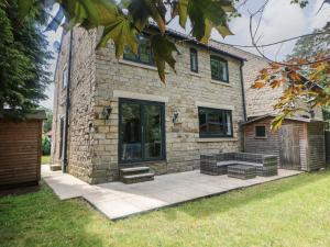 a brick house with a patio in front of it at Millhouses Hideaway in Sheffield